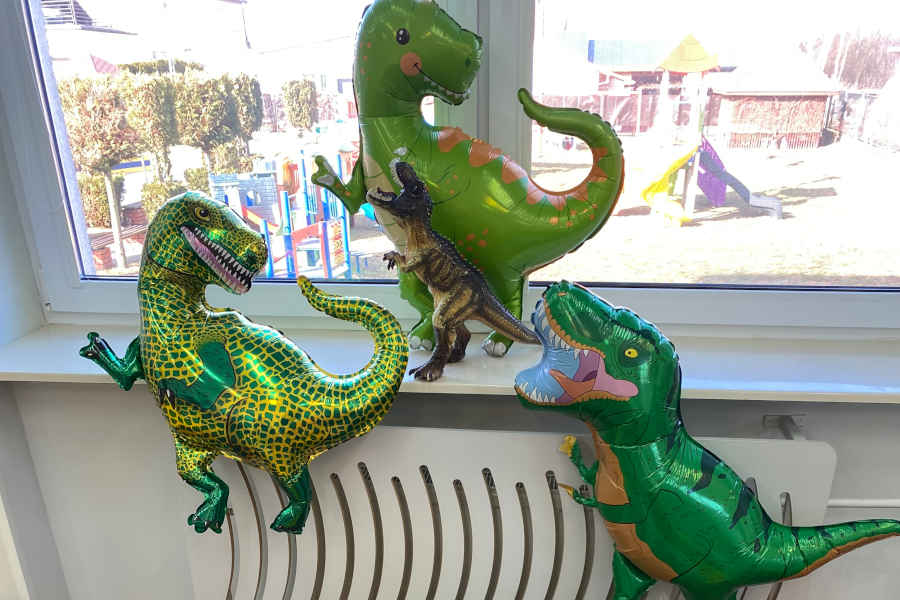 Trzy zielone balony w kształtach dinozaurów