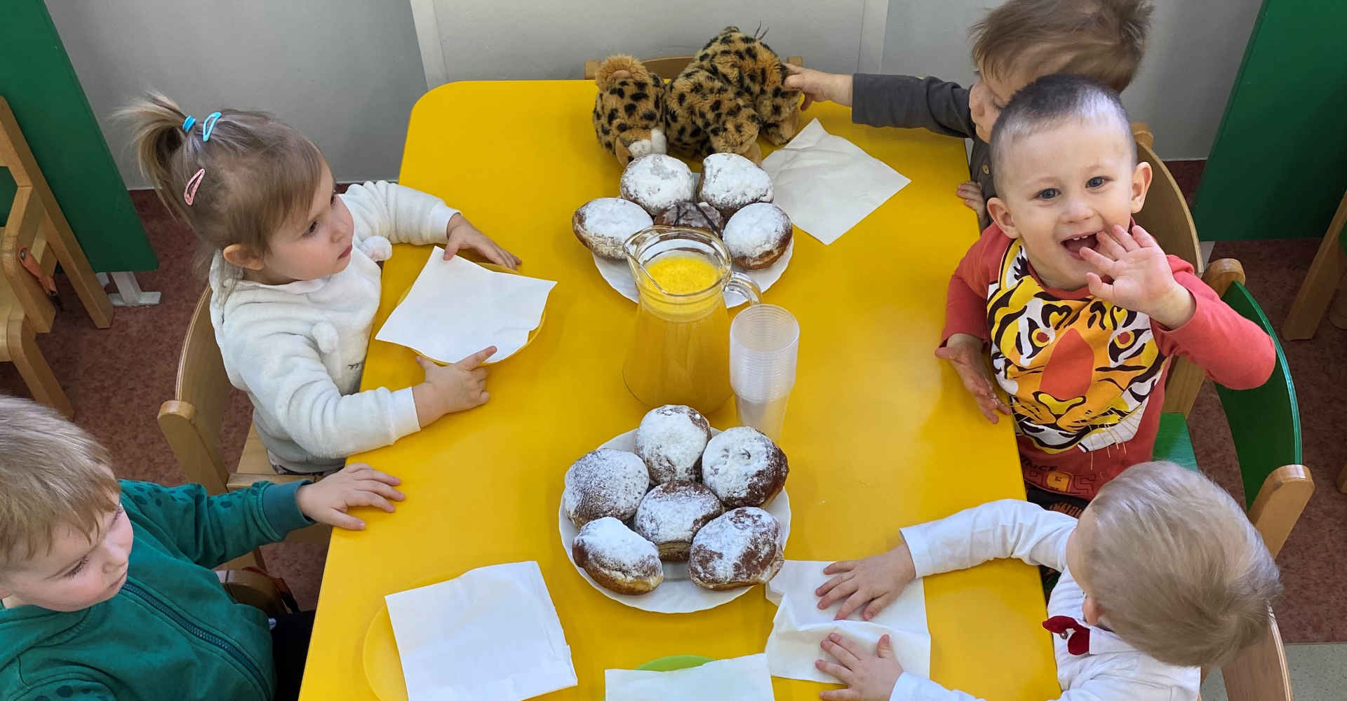 Dzieci przy stole z pączkami