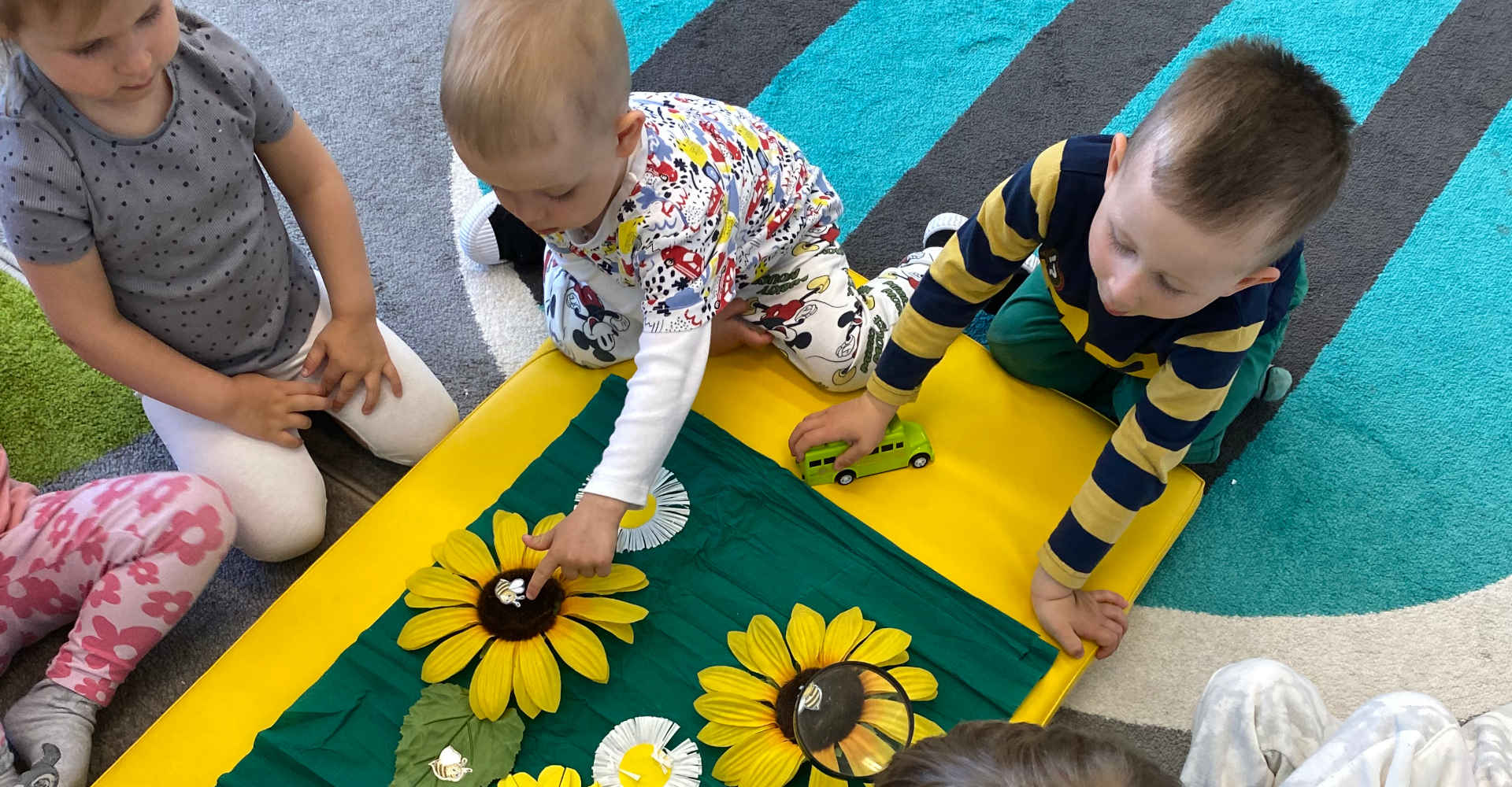 Dzieci szukają pszczół na kwiatkach